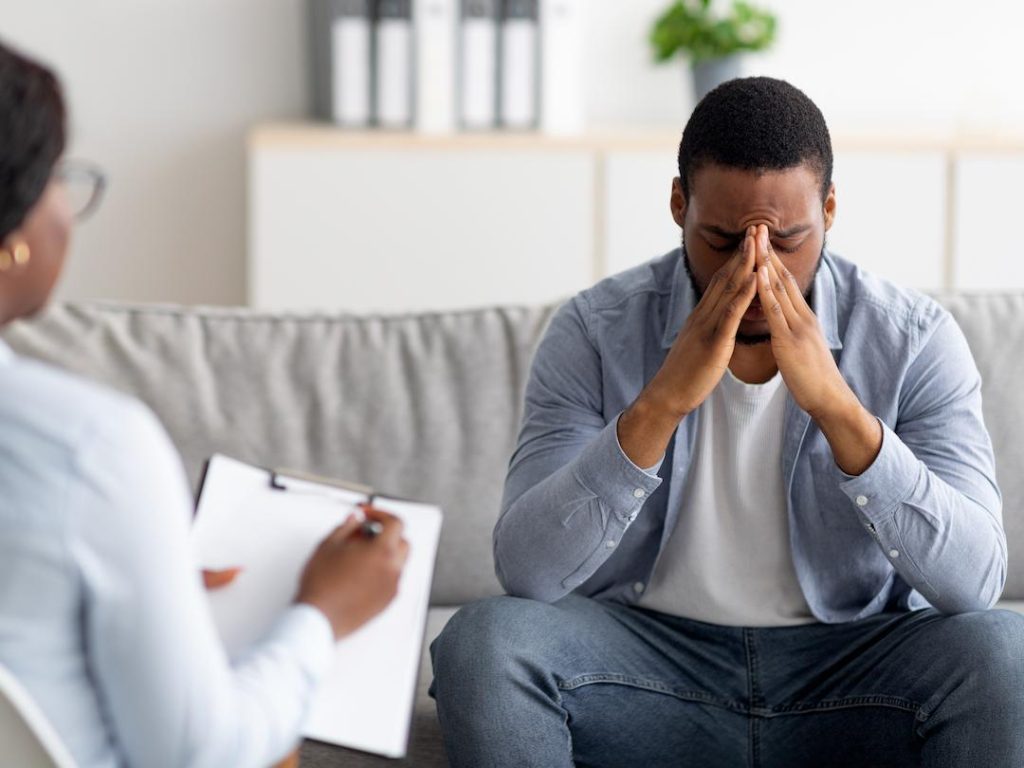 Man With Head In Hands Having Counselling