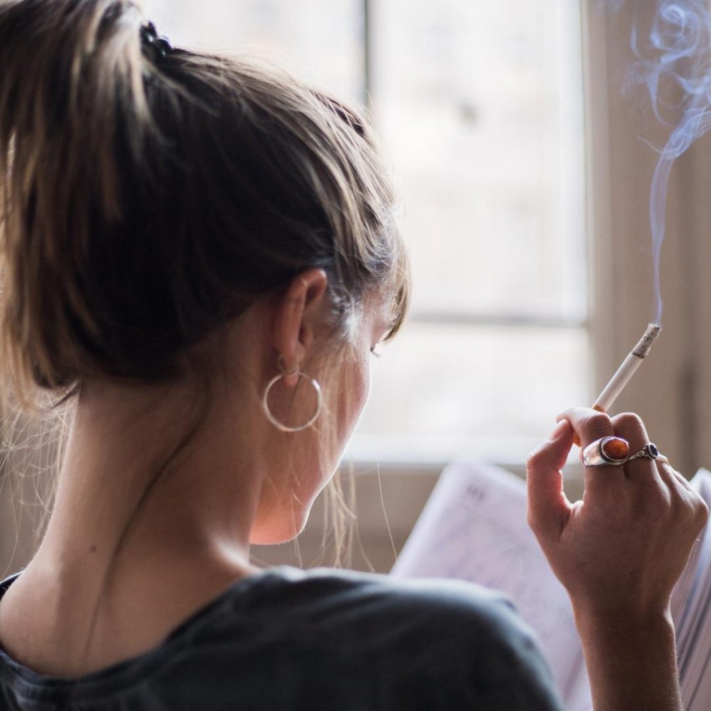 Woman Smoking Whilst Reading A Book
